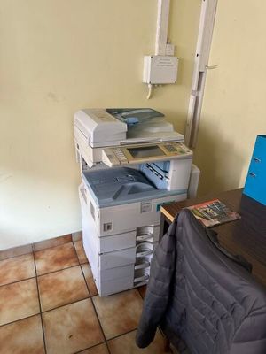 un ordinateur portable posé sur un bureau à côté d'une imprimante