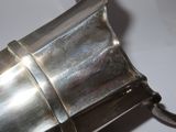 a silver metal object with a handle on a table