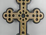 croix en bois rehaussée de touches noires et dorées sur fond blanc