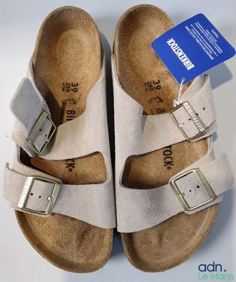 Deux paires de Birkenstock sont présentées sur une surface blanche.