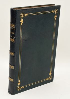 an old black book with gold trim and a gold border