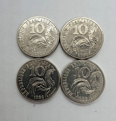 quatre types de pièces différents posés sur une surface blanche