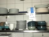 beaucoup d'assiettes et de bols sur les étagères de la cuisine