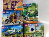 Quatre coffrets Lego City sont exposés sur une table