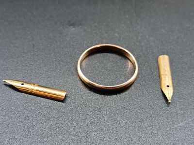 une bague, un stylo et un stylo posés sur une table