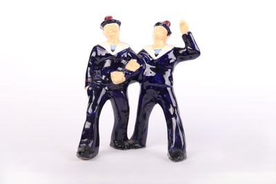 two figurines of a man and a woman standing next to each other