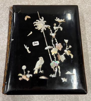 une image représentant une boîte noire ornée d'un oiseau et de fleurs