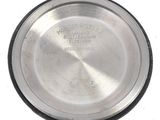 a close up of a silver plate on a white surface