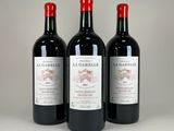 three bottles of red wine sitting next to each other on a table