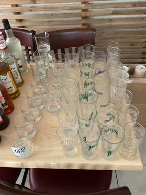many glasses and bottles on a table with bottles on it