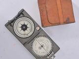 a compass and a wallet on a white surface