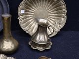 a silver plate and a silver vase on a blue table