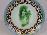 une assiette sur laquelle est représentée une femme tenant une fleur