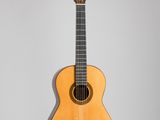 une vieille guitare acoustique accrochée au mur