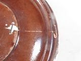 a close up of a brown bowl on a white surface