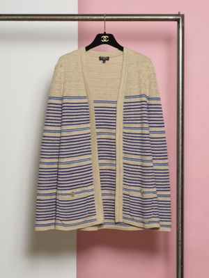 un cardigan rayé beige et bleu suspendu à un cintre