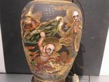 a vase with a painting on it sitting on a table