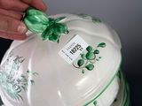 a person holding a green and white plate with a green bow on it