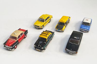 plusieurs petites voitures sont alignées sur une surface blanche