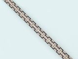 a close up of a black and white bracelet on a white surface