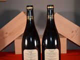 two bottles of wine sitting next to each other on a table