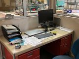 un bureau sur lequel se trouve un ordinateur, avec une chaise bleue devant
