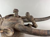 a wooden sculpture of an elephant with people riding on it