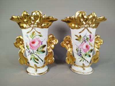deux vases décorés de fleurs, posés sur une table
