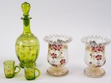three glass vases and a bottle sitting next to each other