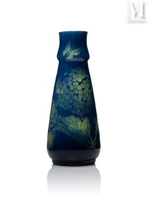 un vase bleu orné d'une fleur verte