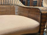 a wicker chair with a cushion on it in a room