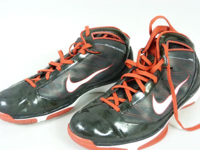 une paire de chaussures noires et orange avec des lacets orange sur fond blanc
