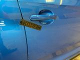 a sticker on the door handle of a blue car