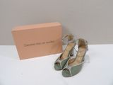 pair of green and silver shoes sitting next to a pink box