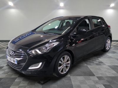 la voiture noire est garée sur un sol en damier dans le garage