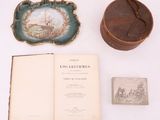 un livre ouvert posé sur une table, à côté d'une petite boîte