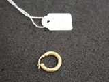 a close up of a gold earring with a tag on it