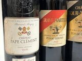 three bottles of red wine are lined up on a table