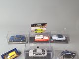 six toy cars in a display case on a table