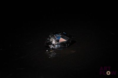 une photo d'un diamant posé par terre, la nuit