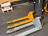 two forklifts that are sitting on the floor in a warehouse