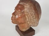sculpture of a man ' s head on a wooden base
