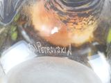 a close up of a glass vase with a bird on it