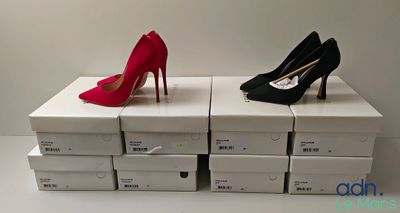 two pairs of red and black high heels sitting on top of boxes