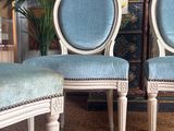 two blue chairs sitting next to each other in a room