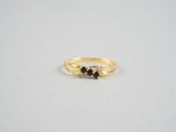 une bague en or surmontée de deux diamants noirs