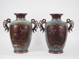 two vases sitting side by side on a white surface