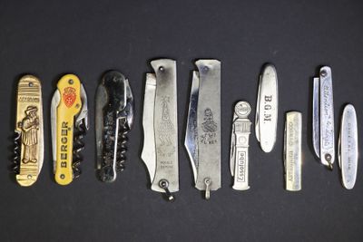 plusieurs types de couteaux sont alignés sur une surface noire
