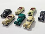 several toy cars are lined up in a row on a white surface