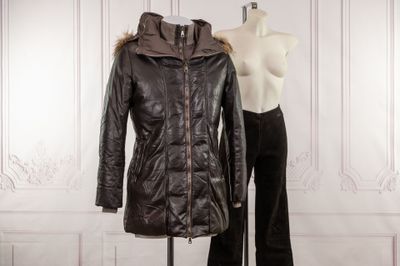 a mannequin and a leather jacket on a mannequin stand